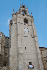Fototapeta na wymiar Vista en contrapicado de uno de los campanarios de la catedral de Palencia bajo el cielo azul