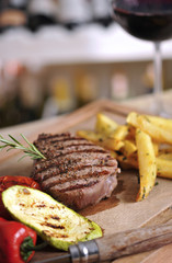 Sirloin steak barbecue with fried potato and red wine on wood table