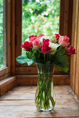 Vase with flowers standing near the window