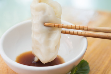 Chinese dumplings or Jiaozi with chopstick on wooden board