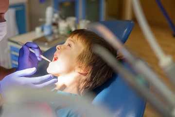 Little child, boy, sitting on a dentist chair, having his yearly
