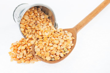 Bucket of peas crumbles in the a wooden spoon