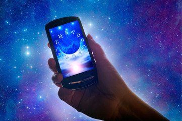 female hand holding a cell phone with astrological background