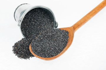 Bucket of poppy crumbles in the a wooden spoon