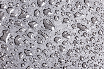 Water bubbles on black surface texture.