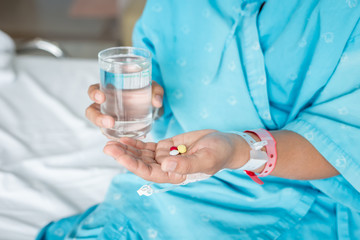 Hand holding medicine in hospital room