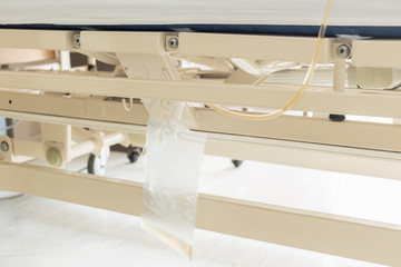 Clear plastic urine bag hang on bed of female patient