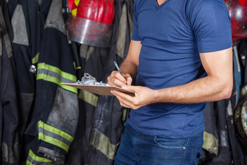 Fototapeta premium Firefighter Writing On Clipboard