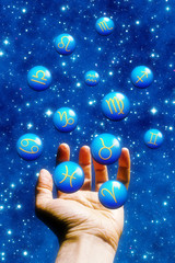 hand juggling spheres with astrology signs