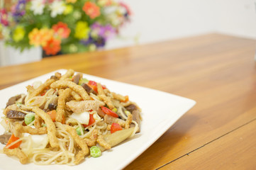 Colorful long life noodle fried vegetarian food with blur flower