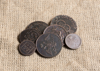 Some brass Russian Empire coins on a burlap canvas
