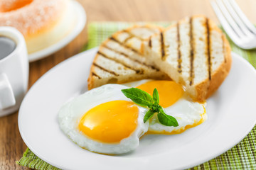 Fried eggs with coffee served for breakfast. Traditional healthy food.