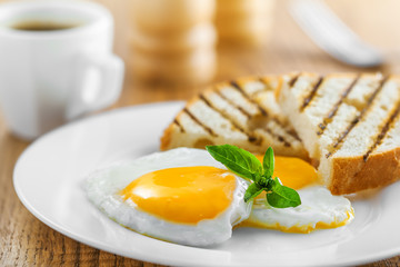Fried eggs with toasts and coffee, traditional breakfast