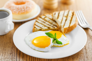 Breakfast with fried eggs, coffee and dessert on table. Healthy food