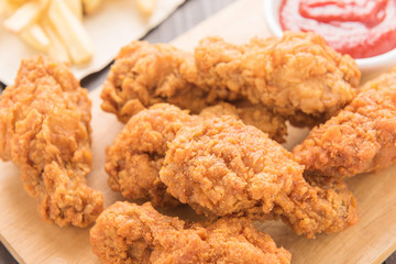 fried chicken drumstick and french fries on wooden table