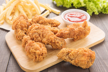 fried chicken drumstick and french fries on wooden table