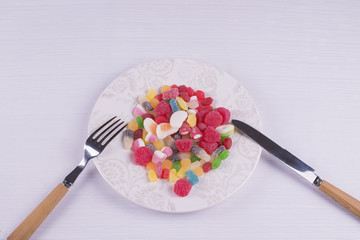 Plate with knife and fork full of candies