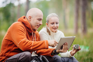Obraz premium Couple of backpackers looking on tablet computer