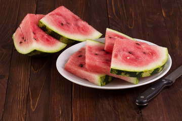 sliced watermelon on a board and slice of watermelon in a white plate