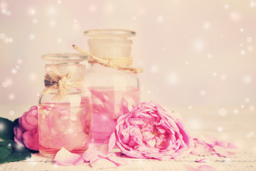 Rose oil in bottles on table, on light background