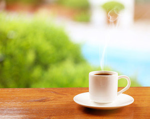 Cup of coffee on table on bright background