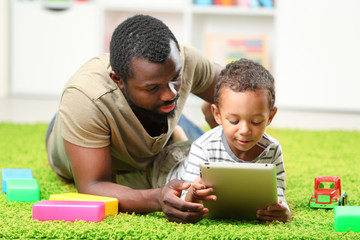 Fototapeta premium Father and son paying in the children room