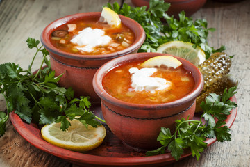Traditional Russian soup - meat solyanka in clay bowls, selectiv
