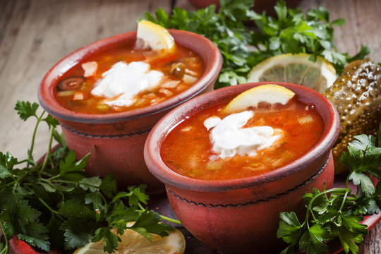 Traditional Russian soup - meat solyanka in clay bowls, selectiv