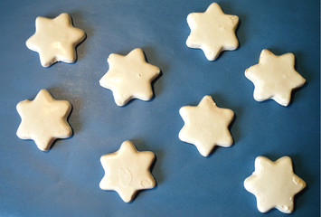 White cookies in the shape of stars on dark blue background