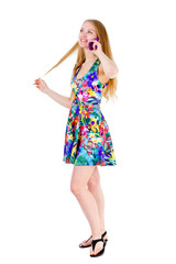 Full body of smile young teenager girl with long blonde hair in mix color dress speak by cell mobile phone, isolated on a white background, Positive human emotions