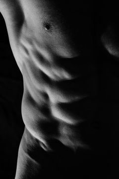 Close-up of perfect male abs, body, low key image. Man, sport, power, muscle
