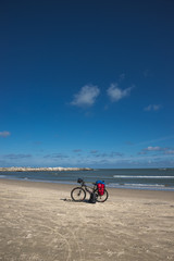 Lonely bike of a traveller on oceanic beach, summer