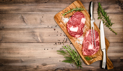 Raw meat Ribeye Steak with herbs and spices. Vintage style