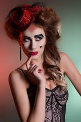 beautiful young sexy girl with lush hair in theatrical retro look with red hat in her hair bright...