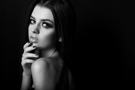 black and white fashion portrait of beautiful sexy young girl with full lips bright makeup black Smokey eyes with black long hair in Studio on a black background