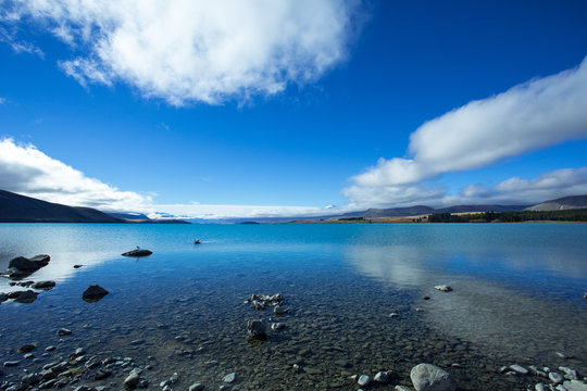 Lake Tekapo has a beautiful blue color, produced by the flow of glacial flour. The lake is located at the center of the South Island of New Zealand.