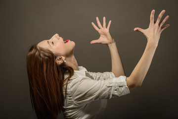 Portrait of beautiful woman singing with her hands raised. Expressing happyines and freedom