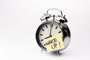 Alarm clock with sticky paper note on white background