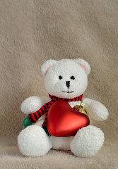 White teddy bear sitting with red heart
