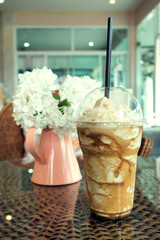 iced frappe coffee in plastic mug put on the rattan weave table