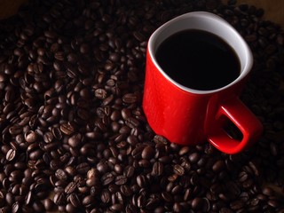 Coffee beans and a red coffee mug
