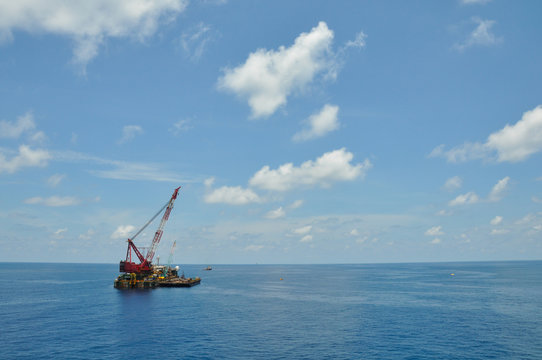 Crane Barge Lifting Heavy Cargo Or Heavy Lift In Offshore Oil And Gas Industry. Large  Boat Working For Lift Piping And Installation The Platform.