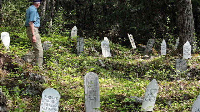Man walking through Gold Rush Historic Cemetery Skagway HD 7170