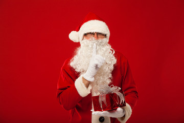 Photo of kind Santa Claus giving xmas present and looking at
