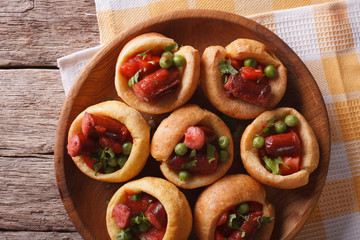 Yorkshire puddings with sausage and green peas closeup horizontal top view
