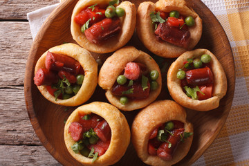 Yorkshire puddings with sausage and vegetables macro horizontal top view
