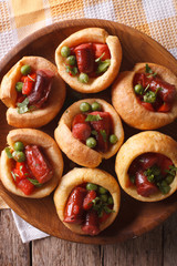 Yorkshire puddings with sausage and vegetables closeup vertical top view
