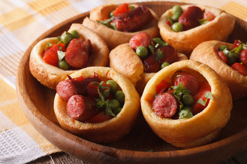 Delicious Yorkshire puddings with sausage and peas closeup. horizontal
