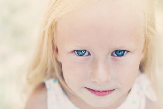 Portrait of Cute Little Girl with Blue Eyes