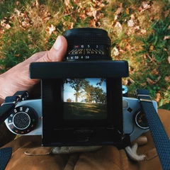 Foto op Plexiglas man photographer is making  landscape photography with old film camera © Yevhenii Kukulka